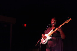 artist playing bass and singing on stage