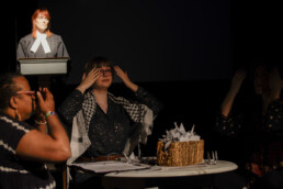 Three performers holding their heads