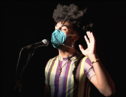 performer singing on stage wearing a mask